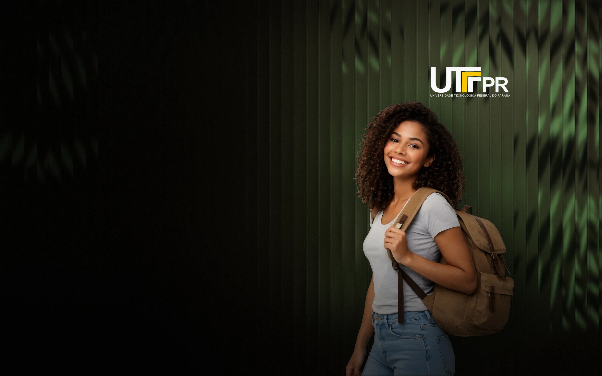 Estudante da UTFPR com mochila, sorrindo, com o logo da UTFPR ao fundo