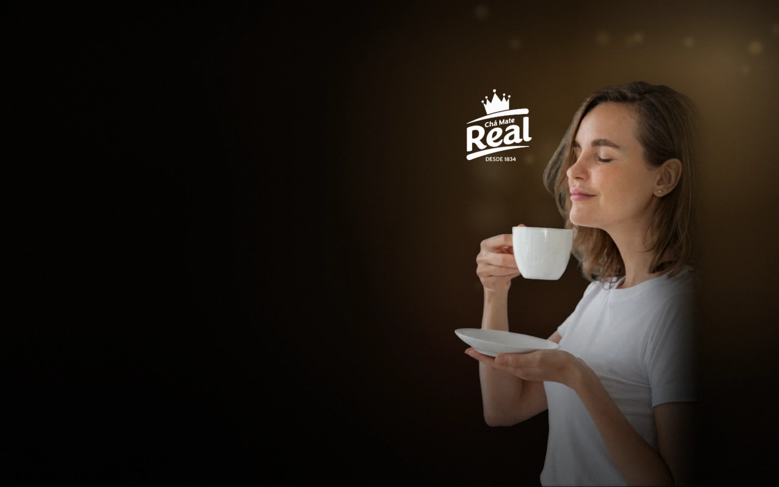 Mulher de olhos fechados sentindo o aroma de uma xícara de chá, ao lado do logo da Chás Real